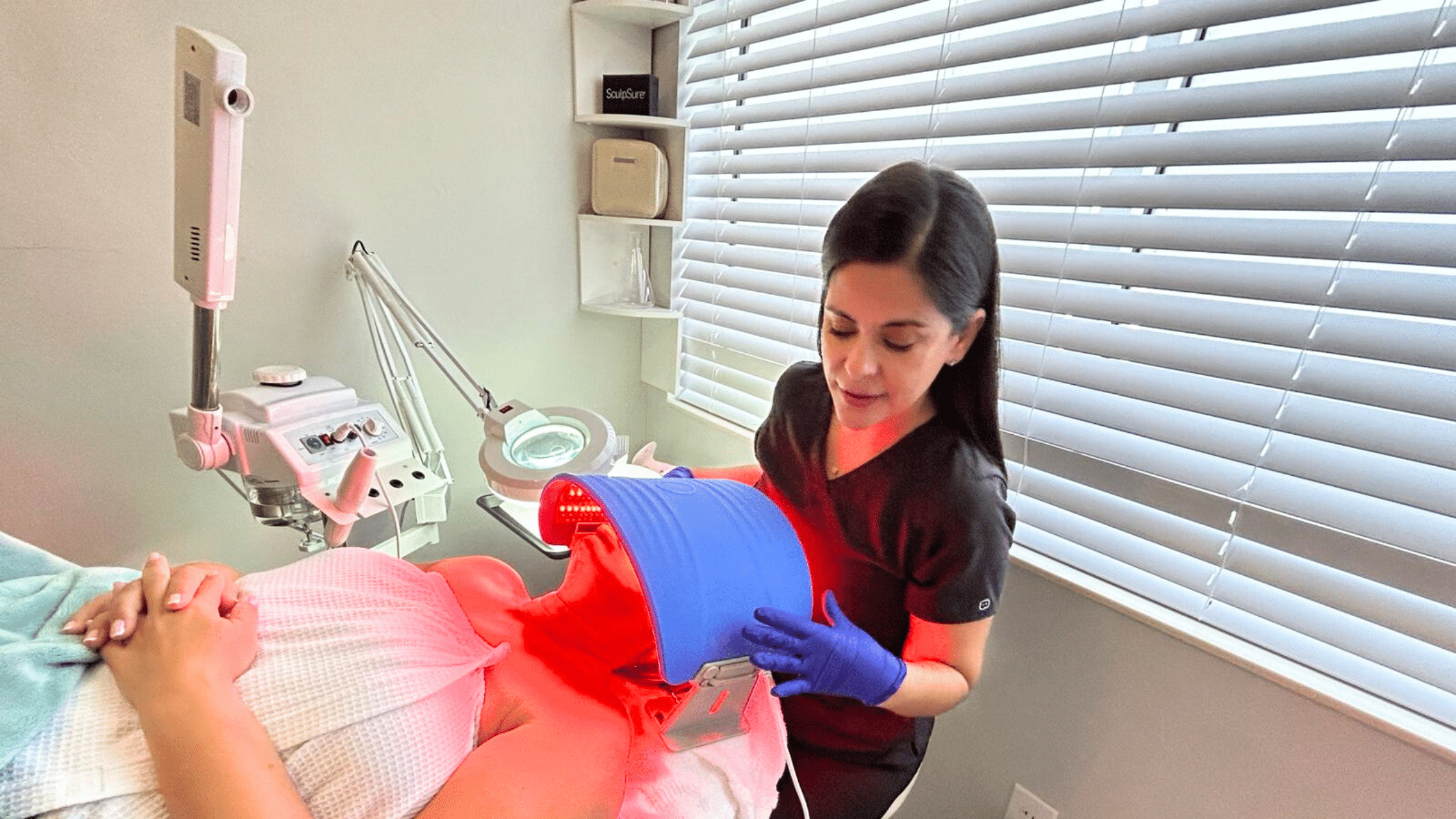 Woman receiving red light therapy treatment.